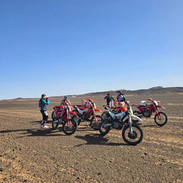 Enduro riders and motorcycles on the rocky hamada plain of the Moroccan Sahara
